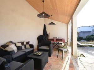 a patio with a couch and chairs and a table at Maison Les Portes-en-Ré, 5 pièces, 6 personnes - FR-1-434-70 in Les Portes