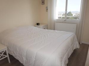 a white bed in a bedroom with a window at Appartement Cabourg, 2 pièces, 4 personnes - FR-1-465-61 in Cabourg