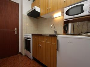 a kitchen with a sink and a microwave at Studio Le Grand-Bornand, 1 pièce, 4 personnes - FR-1-458-89 in Le Grand-Bornand