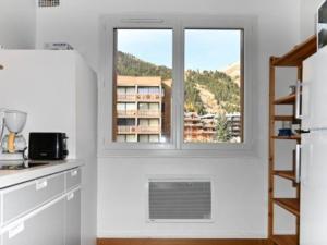 a white kitchen with a window and a staircase at Appartement Montgenèvre, 3 pièces, 8 personnes - FR-1-266-160 in Montgenèvre