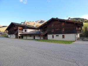 a large wooden house on the side of a road at Studio Le Grand-Bornand, 1 pièce, 4 personnes - FR-1-458-113 in Le Grand-Bornand