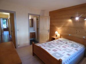 a bedroom with a bed and a wooden wall at Appartement Le Grand-Bornand, 6 pièces, 11 personnes - FR-1-458-137 in Le Grand-Bornand