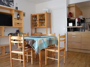 een keuken met een tafel en stoelen en een televisie bij Appartement Les Angles, 2 pièces, 4 personnes - FR-1-593-33 in Les Angles