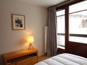 een slaapkamer met een bed, een raam en een lamp bij Appartement Montgenèvre, 2 pièces, 6 personnes - FR-1-330D-115 in Montgenèvre
