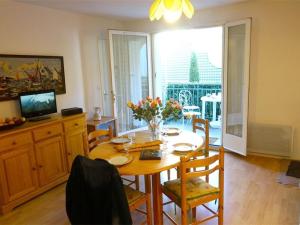 uma sala de jantar com uma mesa com flores em Appartement Bagnères-de-Luchon, 2 pièces, 4 personnes - FR-1-313-123 em Luchon