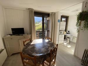 comedor con mesa y cocina con ventana en Appartement Les Angles, 3 pièces, 6 personnes - FR-1-295-154, en Les Angles