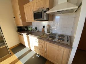 a kitchen with wooden cabinets and a stove top oven at Appartement Les Angles, 2 pièces, 4 personnes - FR-1-295-169 in Les Angles