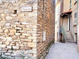 un mur en pierre avec un panneau indiquant la rue dans l'établissement Villa Piedicorte-Di-Gaggio, 4 pièces, 6 personnes - FR-1-61-556, à Sortipiani