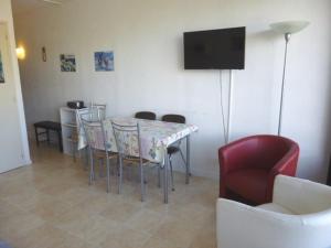 a dining room with a table and chairs and a television at Studio familial 6 pers. accès pistes, balcon, parking gratuit, casier à skis - FR-1-602-24 in Arette +1 photo