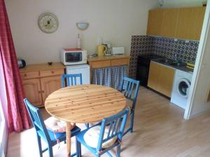 eine Küche mit einem Tisch und Stühlen sowie eine Küche mit einer Mikrowelle in der Unterkunft Appartement Saint-Jean-d'Aulps, 1 pièce, 4 personnes - FR-1-573-38 in Saint-Jean-dʼAulps