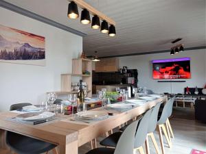 a long wooden table with chairs and a television at Appartement rénové chaleureux et moderne, 120m², 10-12 pers, accès direct aux pistes, stationnement inclus - FR-1-545-20 in Val Thorens