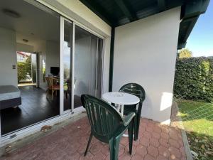 a patio with a table and chairs on a patio at Studio "Anémone" à Cambo, 2 pers., WIFI, animaux perm., parking - FR-1-495-100 in Cambo-les-Bains +2 photos