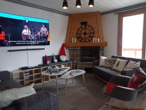 a living room with a couch and a tv at Appartement rénové chaleureux et moderne, 120m², 10-12 pers, accès direct aux pistes, stationnement inclus - FR-1-545-20 in Val Thorens