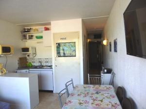 a room with a table and a kitchen with a table and chairs at Studio familial 6 pers. accès pistes, balcon, parking gratuit, casier à skis - FR-1-602-24 in Arette