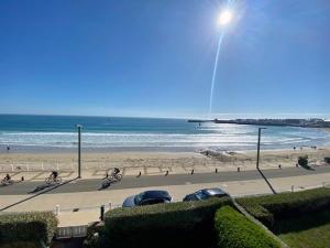 a view of a beach with people on the sand at Quiberon - Grand T2 - Balcon Sud - 70m² - Plage & Centre - Parking & WIFI - FR-1-478-203 in Quiberon +7 photos