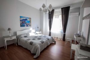 ein weißes Schlafzimmer mit einem Bett und einem Fenster in der Unterkunft Ciuri Ciuri B&B in Palermo