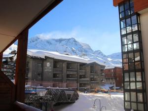 a view of a building with a snow covered mountain at Appartement rénové chaleureux et moderne, 120m², 10-12 pers, accès direct aux pistes, stationnement inclus - FR-1-545-20 in Val Thorens
