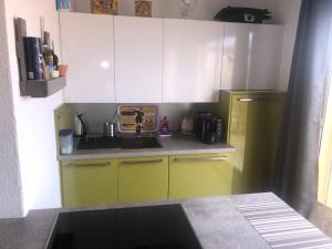 une cuisine avec des armoires jaunes et un réfrigérateur jaune dans l'établissement Studio Port Leucate, 2 pièces, 4 personnes - FR-1-81-536, à Port-Leucate