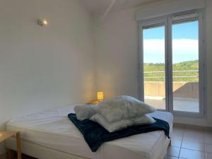 een witte slaapkamer met een bed en een raam bij Appartement Banyuls-sur-Mer, 3 pièces, 6 personnes - FR-1-225C-88 in Banyuls-sur-Mer