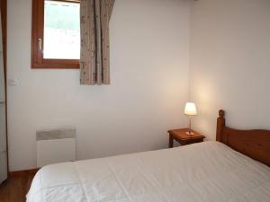 a bedroom with a white bed and a window at Appartement Les Orres, 2 pièces, 6 personnes - FR-1-322-438 in Les Orres