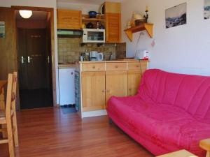 a living room with a red couch and a kitchen at Appartement Le Grand-Bornand, 3 pièces, 6 personnes - FR-1-458-93 in Le Grand-Bornand