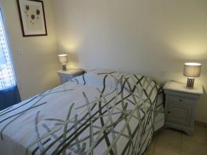 ein Schlafzimmer mit einem Bett mit zwei Nachttischen und zwei Lampen in der Unterkunft T3 68m², 4*, climatisé avec loggia, proche mer et commerces – Bormes-les-Mimosas - FR-1-610-14 in Bormes-les-Mimosas