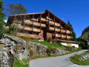 um edifício numa colina ao lado de uma estrada em Appartement Le Grand-Bornand, 3 pièces, 6 personnes - FR-1-458-93 em Le Grand-Bornand