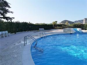 a large swimming pool with blue water and stairs at Appartement Mandelieu-la-Napoule, 2 pièces, 4 personnes - FR-1-609-60 in Mandelieu-La Napoule