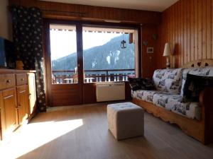 ein Wohnzimmer mit einem Sofa und einem großen Fenster in der Unterkunft Studio Le Grand-Bornand, 2 pièces, 4 personnes - FR-1-458-120 in Le Grand-Bornand
