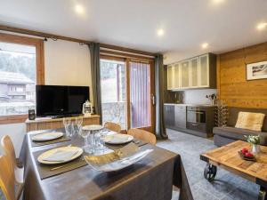 Una sala de estar con mesa de comedor y una cocina. en Bel appartement rénové, 4 pers, balcon, casier à skis - FR-1-291-865, en Valmorel