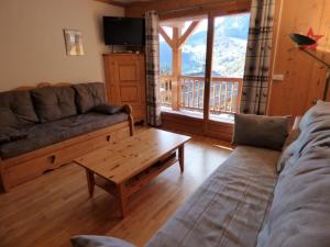 un salon avec un canapé et une table basse dans l'établissement Charmant appartement au pied des pistes - 41m² - 6 pers - Ambiance Montagne - Garage fermé inclus - FR-1-458-109, au Grand-Bornand
