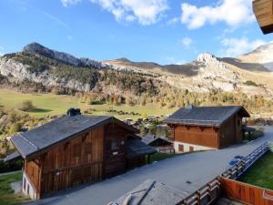 - une vue de tête sur deux granges et une montagne dans l'établissement Charmant appartement au pied des pistes - 41m² - 6 pers - Ambiance Montagne - Garage fermé inclus - FR-1-458-109, au Grand-Bornand