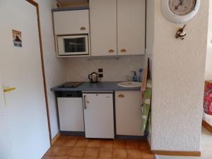 eine kleine Küche mit einer Spüle und einer Mikrowelle in der Unterkunft Studio Le Grand-Bornand, 2 pièces, 4 personnes - FR-1-458-120 in Le Grand-Bornand