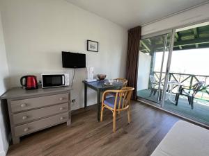 a room with a desk and a table with a microwave at Studio Cambo-les-Bains, 1 pièce, 2 personnes - FR-1-495-98 in Cambo-les-Bains