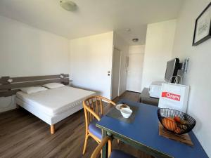 ein kleines Zimmer mit einem Bett und einem Tisch und ein Zimmer mit einem Bett in der Unterkunft Studio Lys à Cambo-les-Bains, 2 pers, Terrasse & Parking, Proche Thermes, Animaux Acceptés - FR-1-495-98 in Cambo-les-Bains