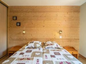 ein Schlafzimmer mit einem Bett mit einer Holzwand in der Unterkunft Charmant T2 avec parking à Valmorel - FR-1-291-867 in Valmorel + 3 Fotos