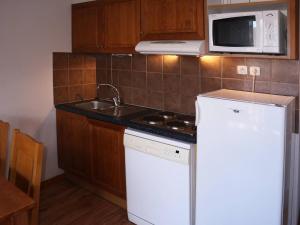 a kitchen with a white refrigerator and a microwave at Appartement Les Orres, 2 pièces, 4 personnes - FR-1-322-425 in Les Orres