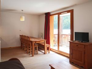 ein Wohnzimmer mit einem Holztisch und einem TV in der Unterkunft Appartement Les Orres, 3 pièces, 10 personnes - FR-1-322-424 in Les Orres