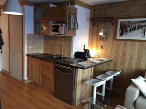 a kitchen with a sink and a counter with stools at Studio Val Thorens, 2 pièces, 3 personnes - FR-1-637-2 in Val Thorens