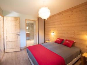 a bedroom with a large bed and a chandelier at Appartement Les Avanchers-Valmorel, 2 pièces, 4 personnes - FR-1-291-860 in Valmorel