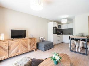 ein Wohnzimmer mit Fernseher und Tisch in der Unterkunft Charmette 2 pièces avec parking, terrasse et casier à skis - FR-1-291-860 in Valmorel
