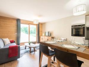 eine Küche und ein Wohnzimmer mit Tisch und Stühlen in der Unterkunft Charmette 2 pièces avec parking, terrasse et casier à skis - FR-1-291-860 in Valmorel