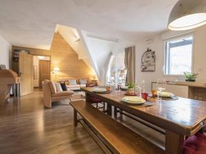 a living room with a wooden table and a dining room at Duplex 10 pers à Saint-Lary-Soulan avec jacuzzi et sauna - FR-1-296-340 in Saint-Lary-Soulan +12 photos