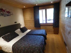 a bedroom with a bed and a large window at Appartement Le Grand-Bornand, 6 pièces, 14 personnes - FR-1-458-101 in Le Grand-Bornand