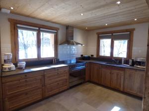 a large kitchen with wooden cabinets and windows at Appartement Le Grand-Bornand, 6 pièces, 14 personnes - FR-1-458-101 in Le Grand-Bornand