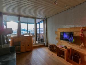 un salon avec un canapé, une télévision et une table dans l'établissement Appartement rénové montagne à Val Thorens - 6 pers, 34 m², Veranda, Ski In/Out, WIFI - FR-1-637-6, à Val Thorens