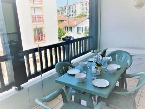 einen blauen Tisch mit Stühlen auf dem Balkon in der Unterkunft Appartement Saint-Jean-de-Luz, 3 pièces, 5 personnes - FR-1-4-612 in Saint-Jean-de-Luz