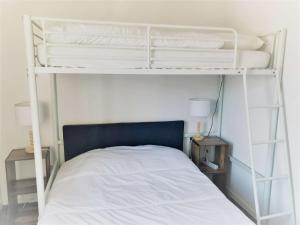 een slaapkamer met 2 stapelbedden met witte lakens bij Appartement Saint-Jean-de-Luz, 3 pièces, 5 personnes - FR-1-4-612 in Saint-Jean-de-Luz