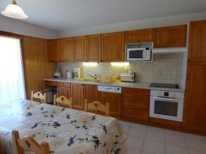 a kitchen with wooden cabinets and a table and a microwave at Appartement Saint-Jean-de-Sixt, 3 pièces, 6 personnes - FR-1-458-134 in Saint-Jean-de-Sixt