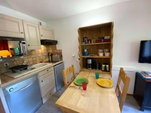 a small kitchen with a wooden table and a sink at Appartement Le Grand-Bornand, 1 pièce, 3 personnes - FR-1-241-238 in Le Grand-Bornand